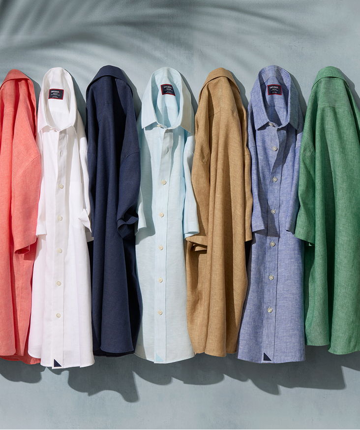 Colorful shirts displayed hanging against a light blue background.