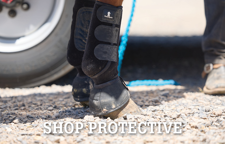 Person wearing a protective boot near a vehicle on gravel.