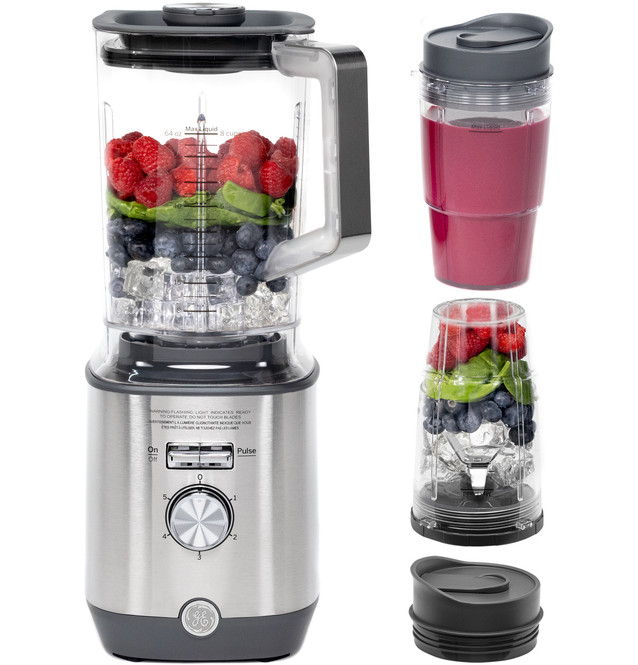 A blender with fruits and a portable blending cup.