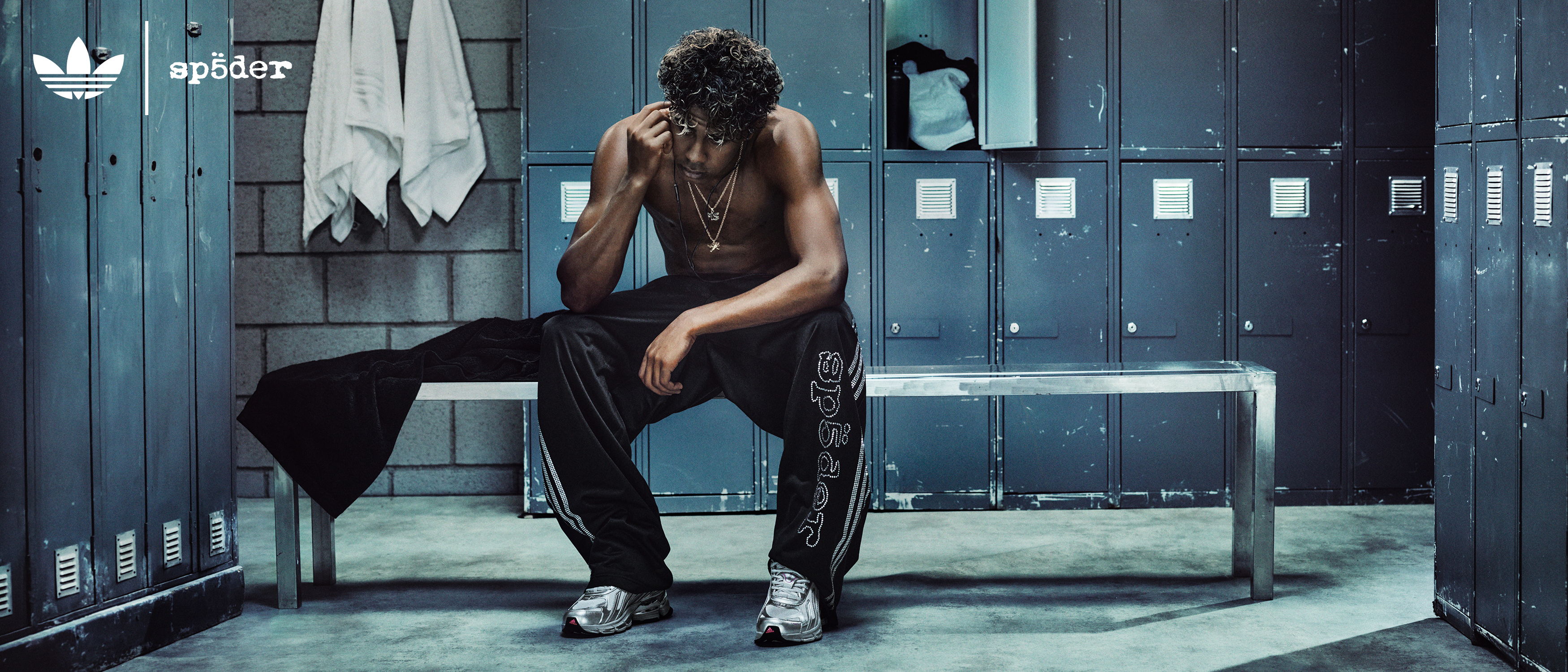 A person sitting on a bench in a locker room.