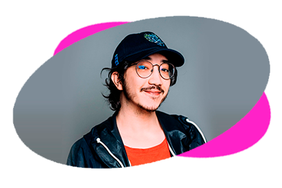 Person smiling, wearing glasses and a cap, against a colorful background.