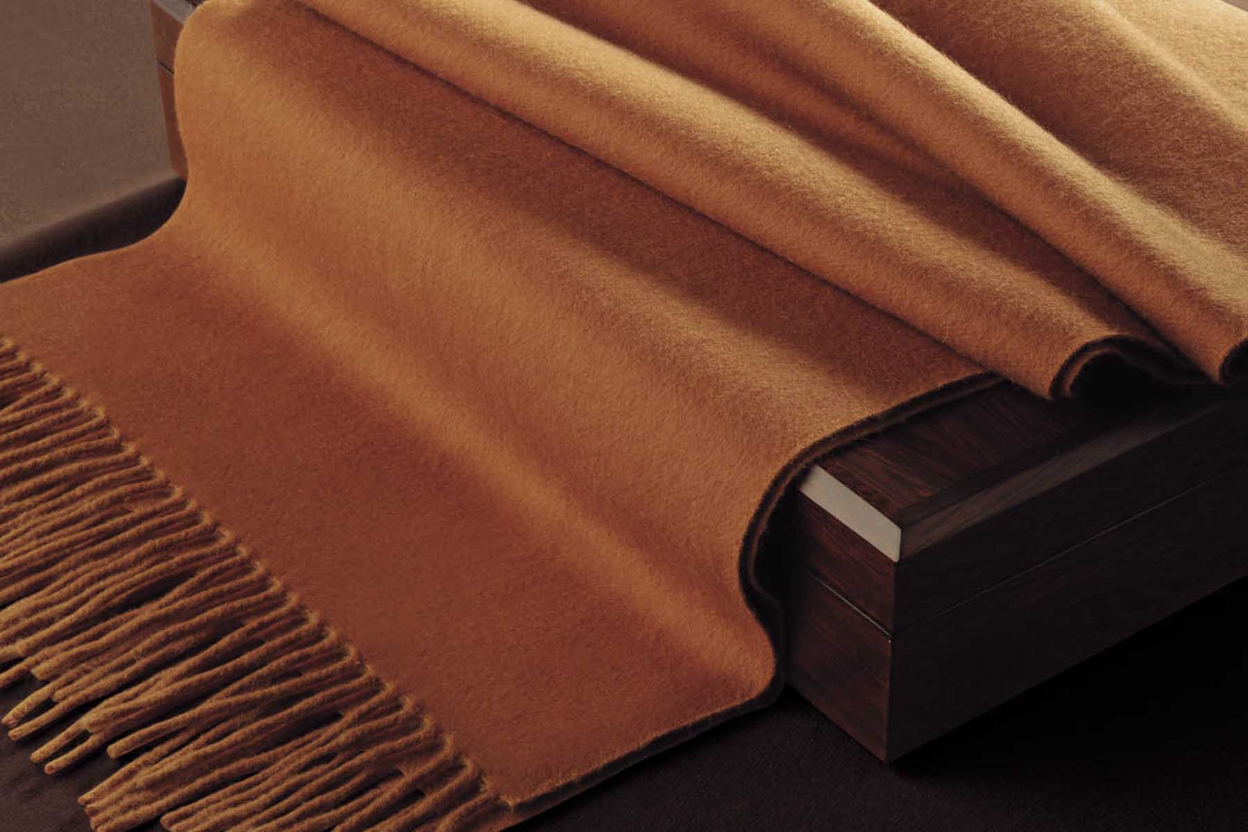 A warm, brown fabric draped elegantly over a wooden surface.