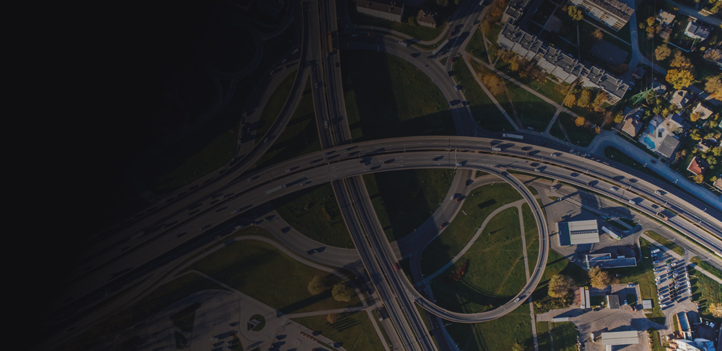 Aerial view of a complex highway interchange with vehicles and greenery