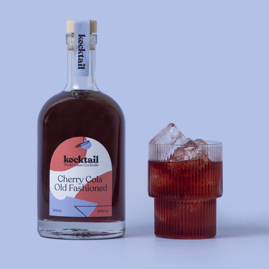 Old Fashioned bottle and cocktail on blue background