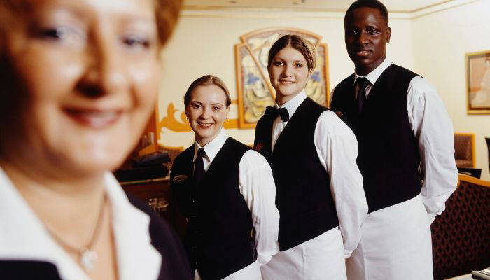 Restaurant waiters wearing black bow ties and vests