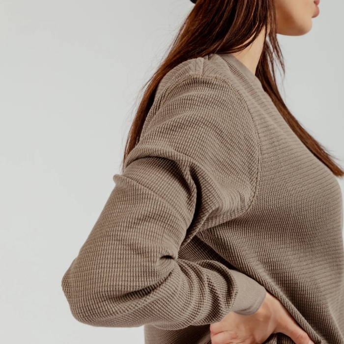 close up of female model wearing brown henley long sleeve shirt