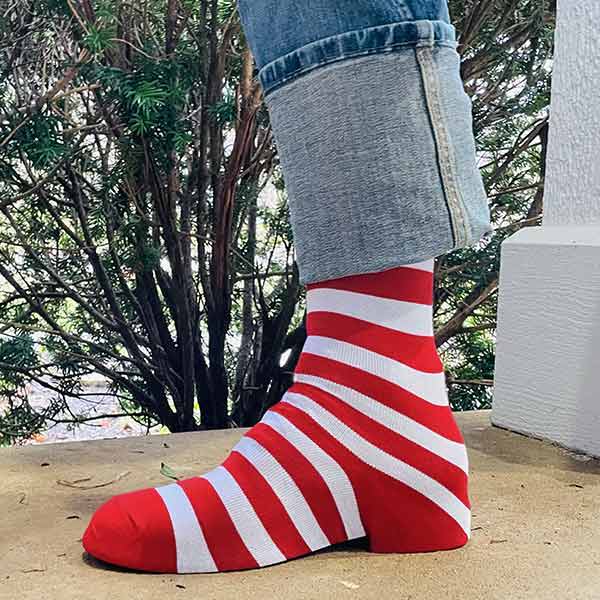 AI generated-like photo if a man wearing jeans with a red and white striped sock that looks like a shoe