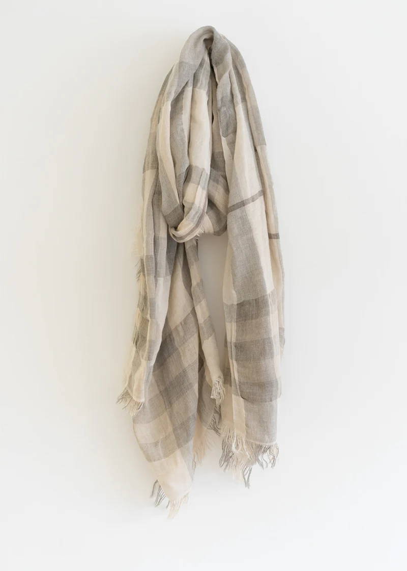 A light grey and beige scarf with a check pattern and raw hems