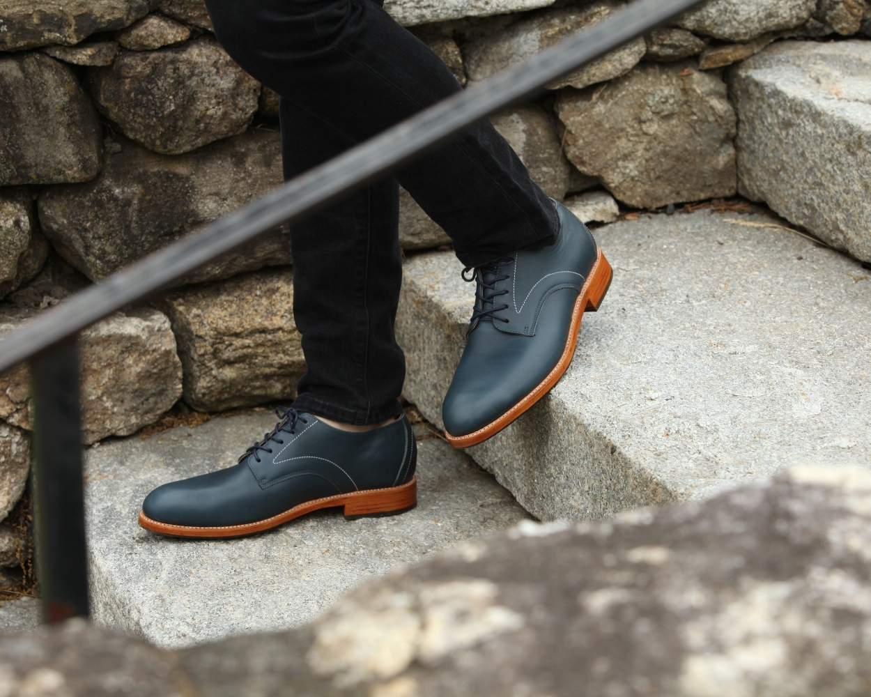 Close-up view of a man walking in Adelante denim blue premium leather wide width dress shoes with a natural brown sole.