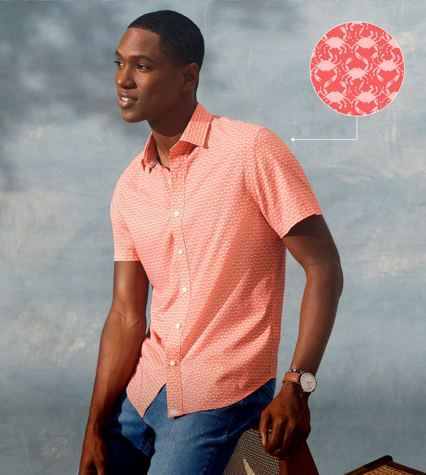 Man in a pink shirt posing against a soft background.