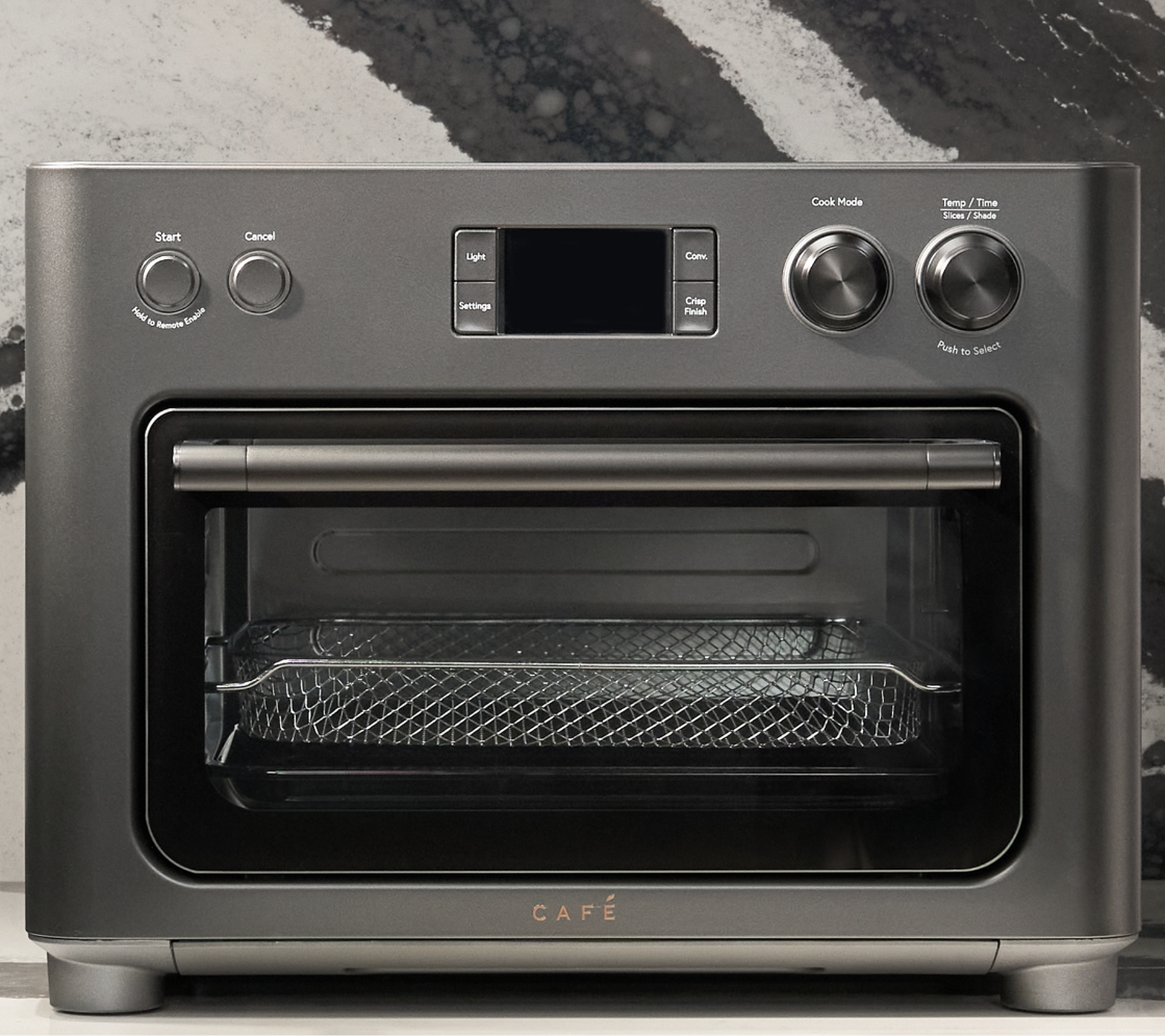 A modern countertop oven with digital display and control knobs.