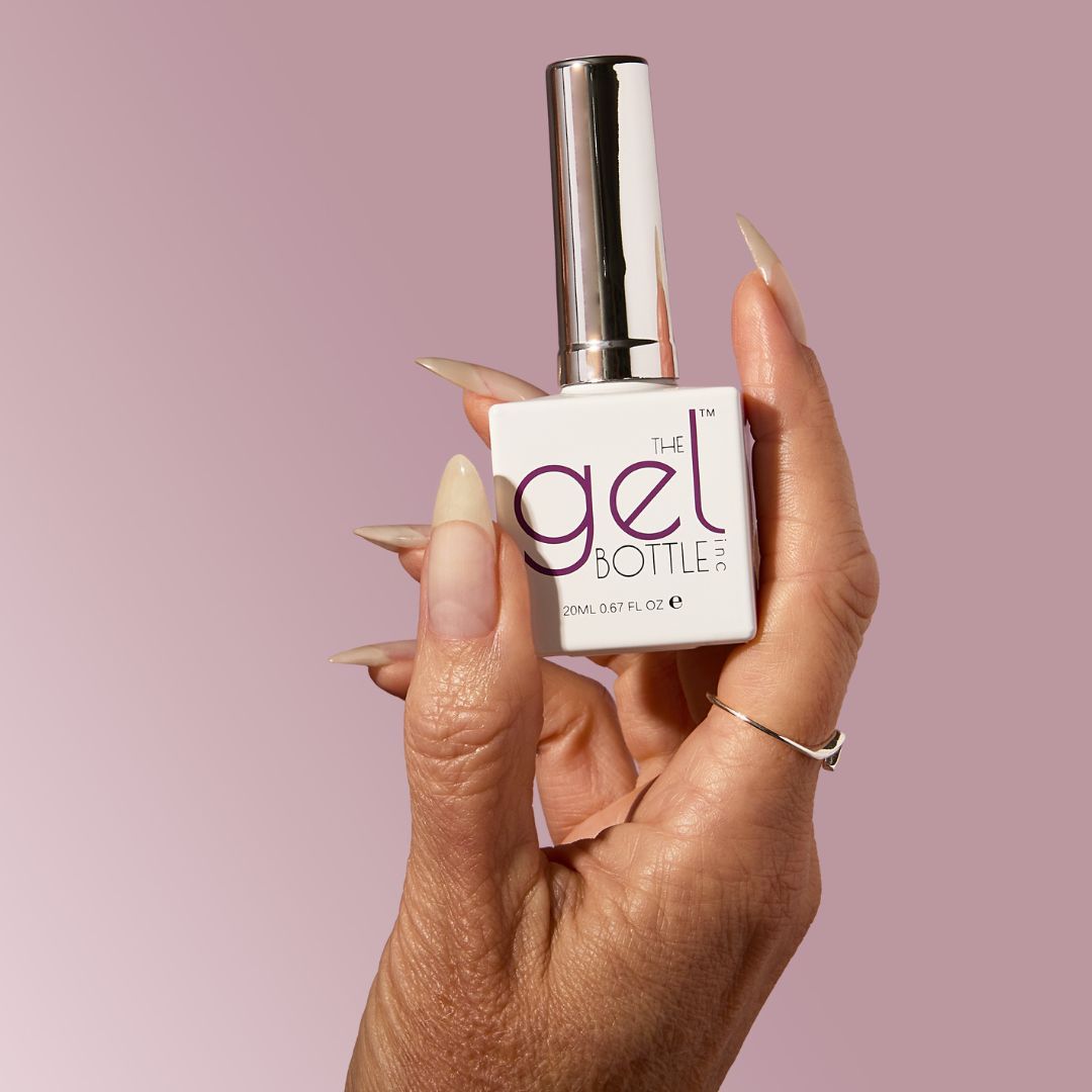 The GelBottle Inc top coat held against a purple background. 