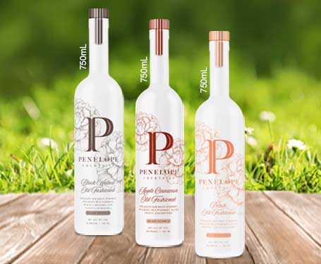 Three bottles of vodka on a wooden surface, with a grassy background.