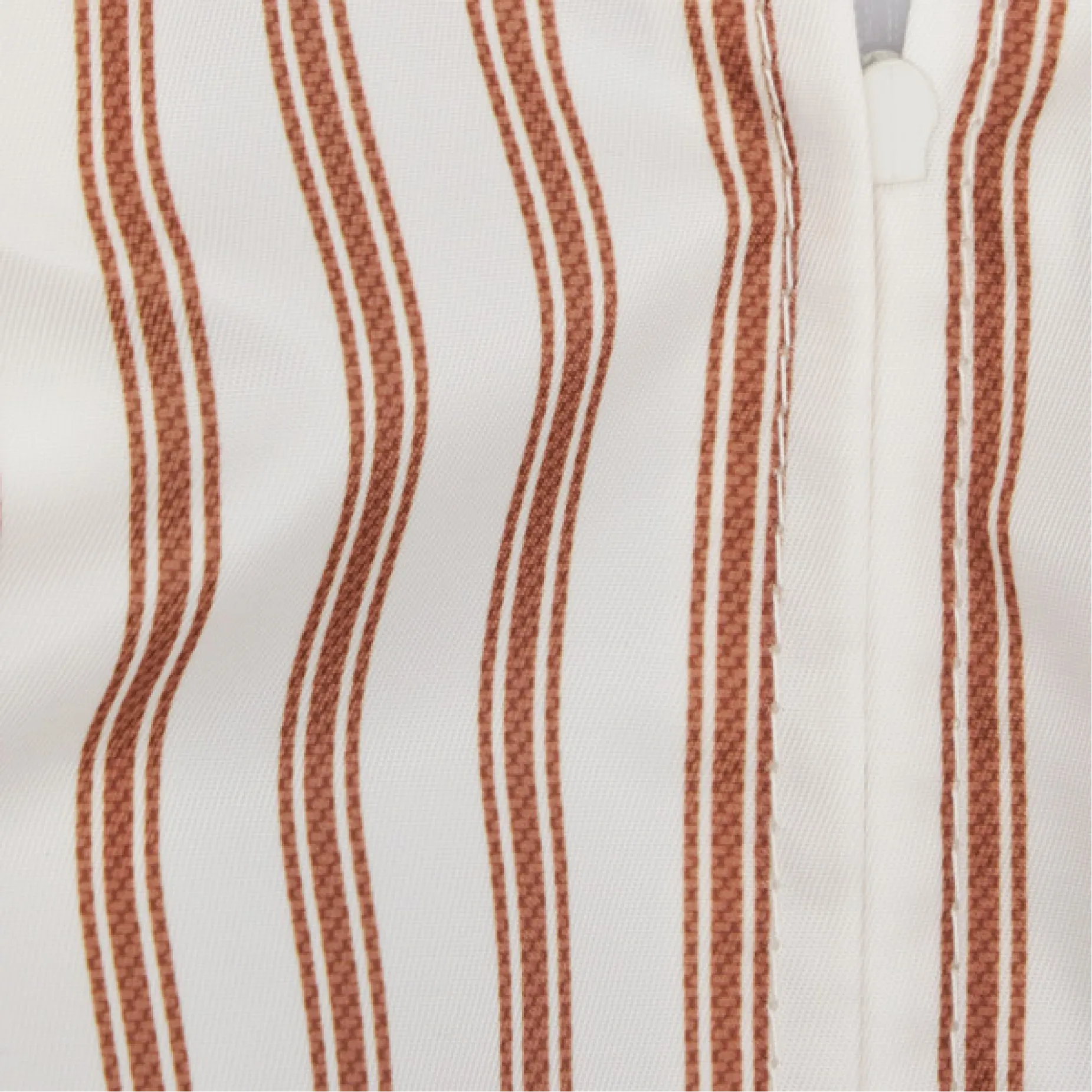 Close-up of fabric with vertical white and brown stripes.