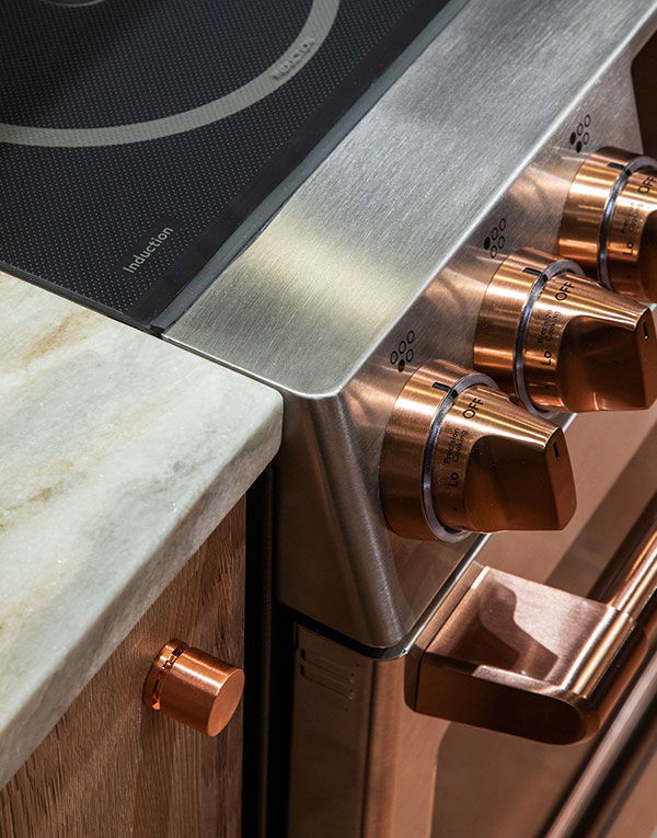 Stainless steel induction range with copper knobs and handles