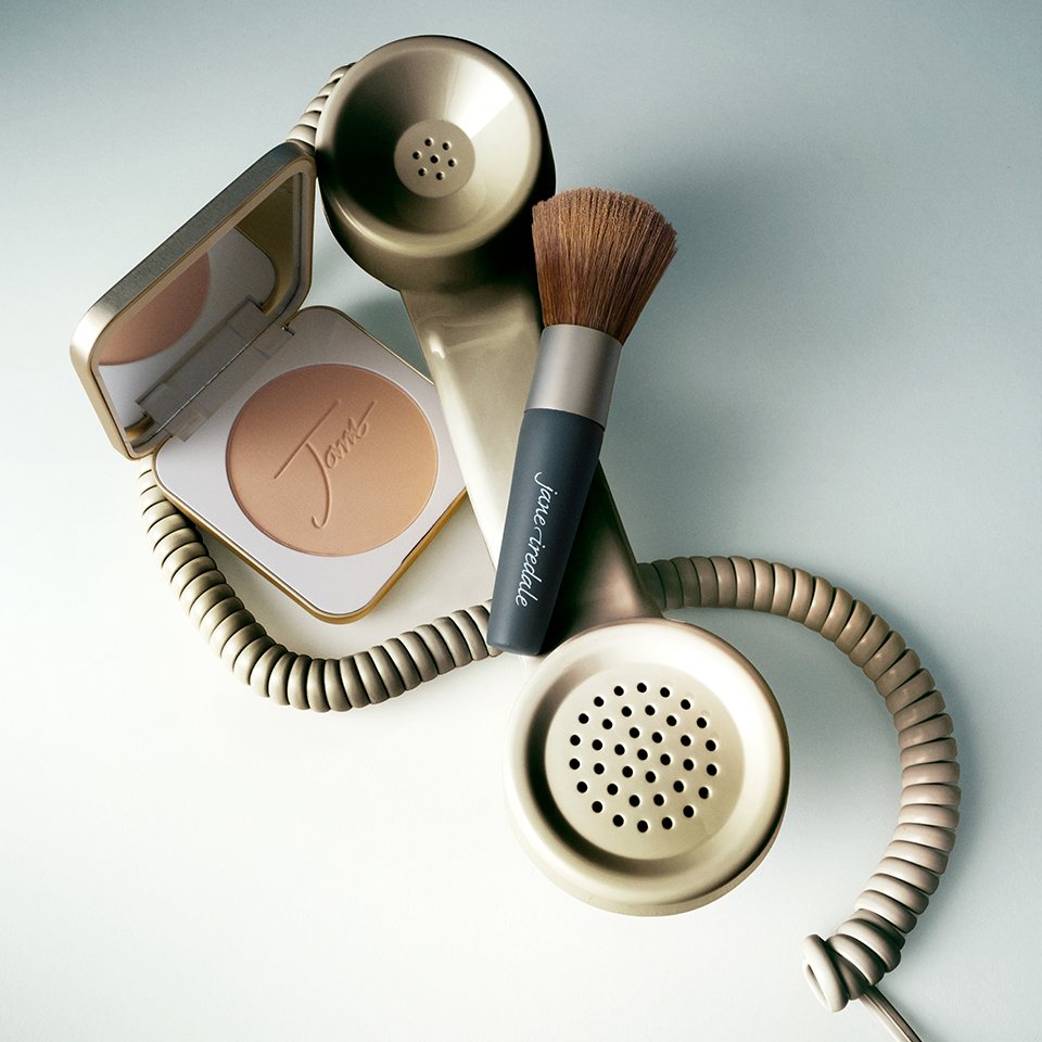Makeup products and a vintage telephone arranged artistically.