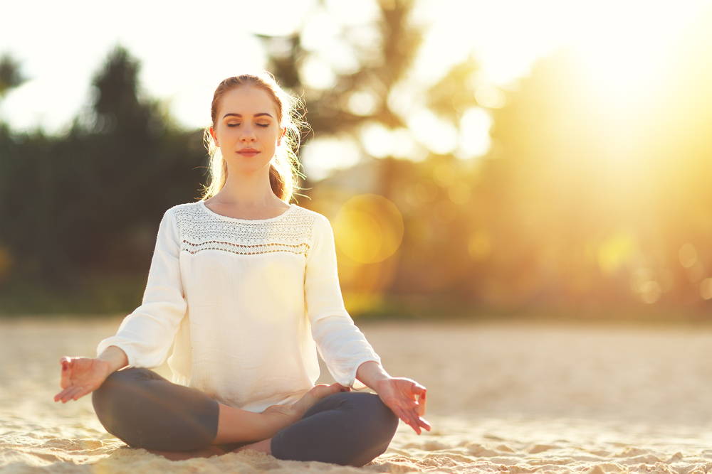 woman practices yoga and meditates in the lotus position on the beach|Meditation Is Magical for Heart Health