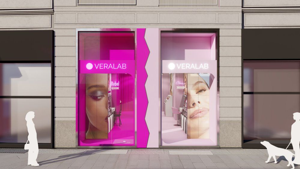 Storefront with pink signage featuring beauty advertisements and pedestrians.