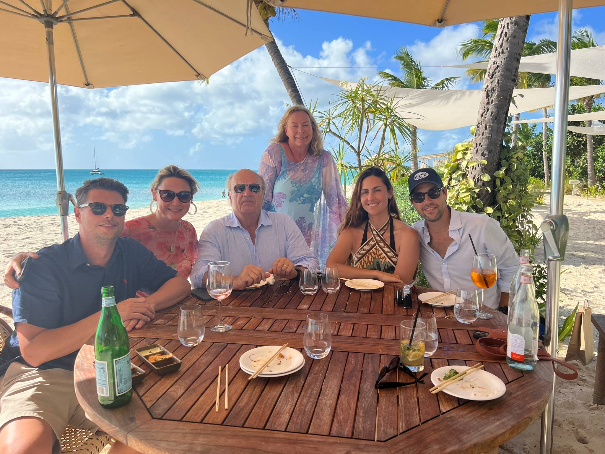 Ala and Ralph Isham and family at Nobu Restaurant on the island of Barbuda in the Caribbean wearing mesh printed toppers by Ala von Auersperg