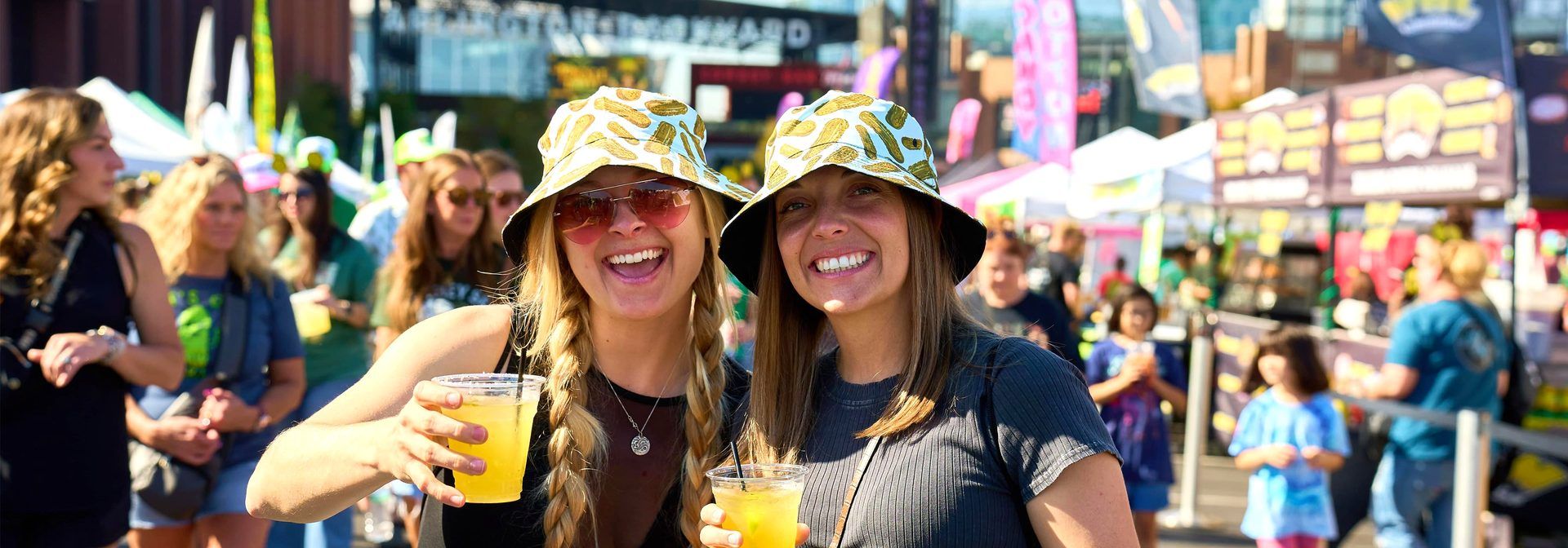 Friends in pickle bucket hats with Teremana tequila pickle margaritas at The Big Dill pickle festival 2025 in Arlington Texas