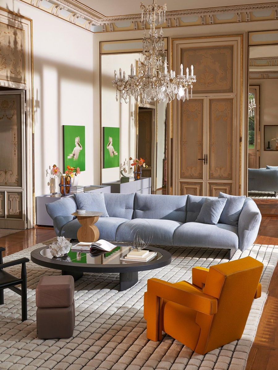 A modern living room with a Cassina sofa, decorative pillows, and art on the walls.