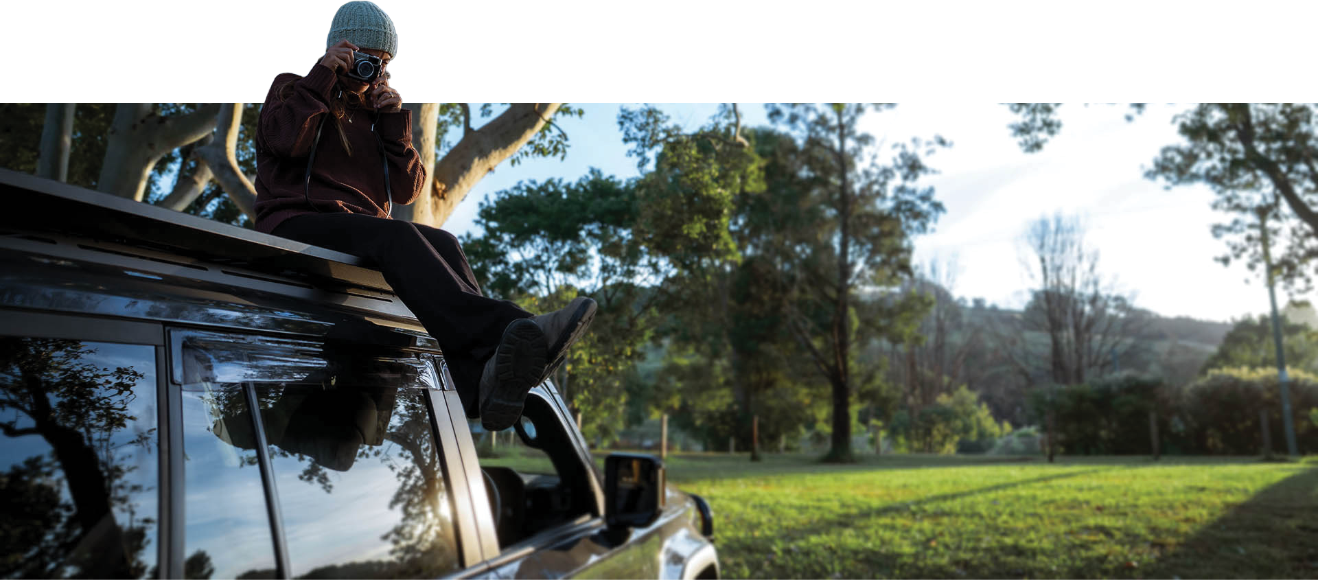 A person sitting on top of a vehicle in the forest