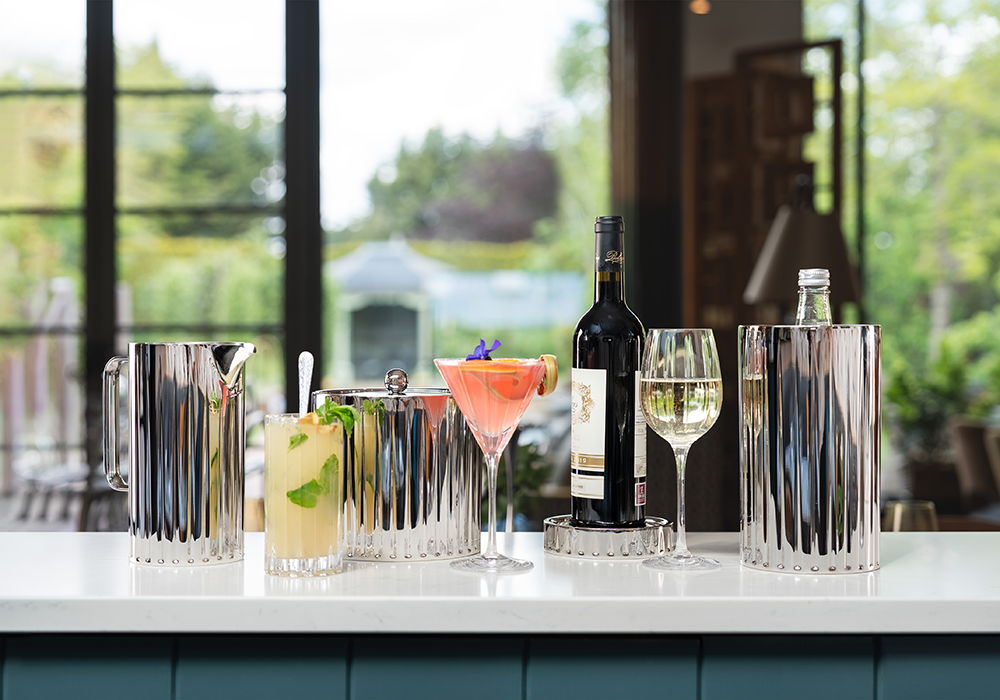Dorset Barware on a countertop with greenery outside.