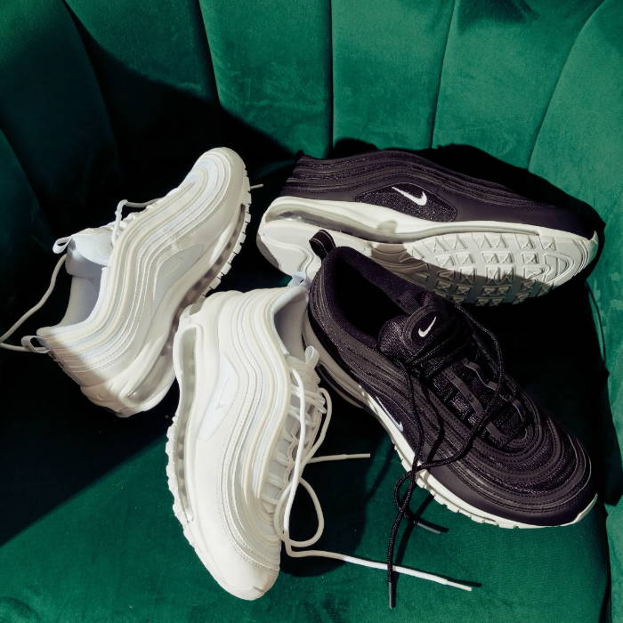 white and black nike air max shoes on velvet green chair