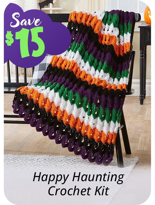 Colorful Halloween-themed crochet blanket displayed on a chair with a savings tag.