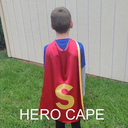  A red superhero cape with a yellow S worn by a boy