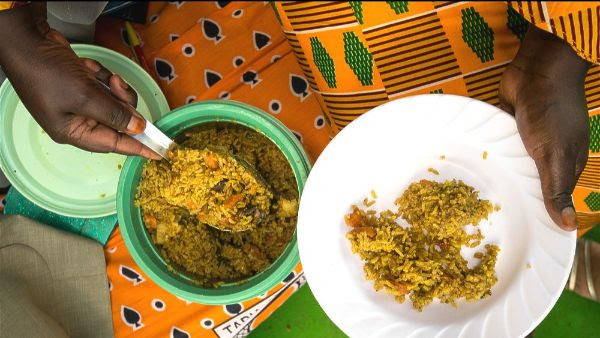 pilau african rice in a green pot being served on a plate by a woman in colorful organge pattern