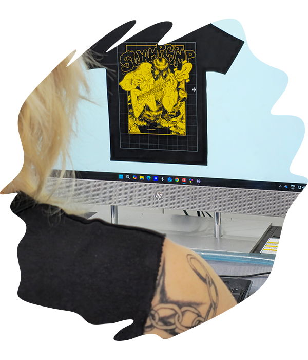 Computer screen showing t-shirt template with bold yellow graphic being aligned and prepared for printing.