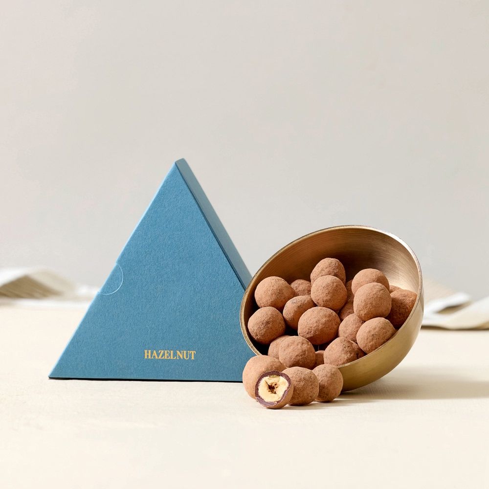 A blue triangular box next to a bowl of round snacks.