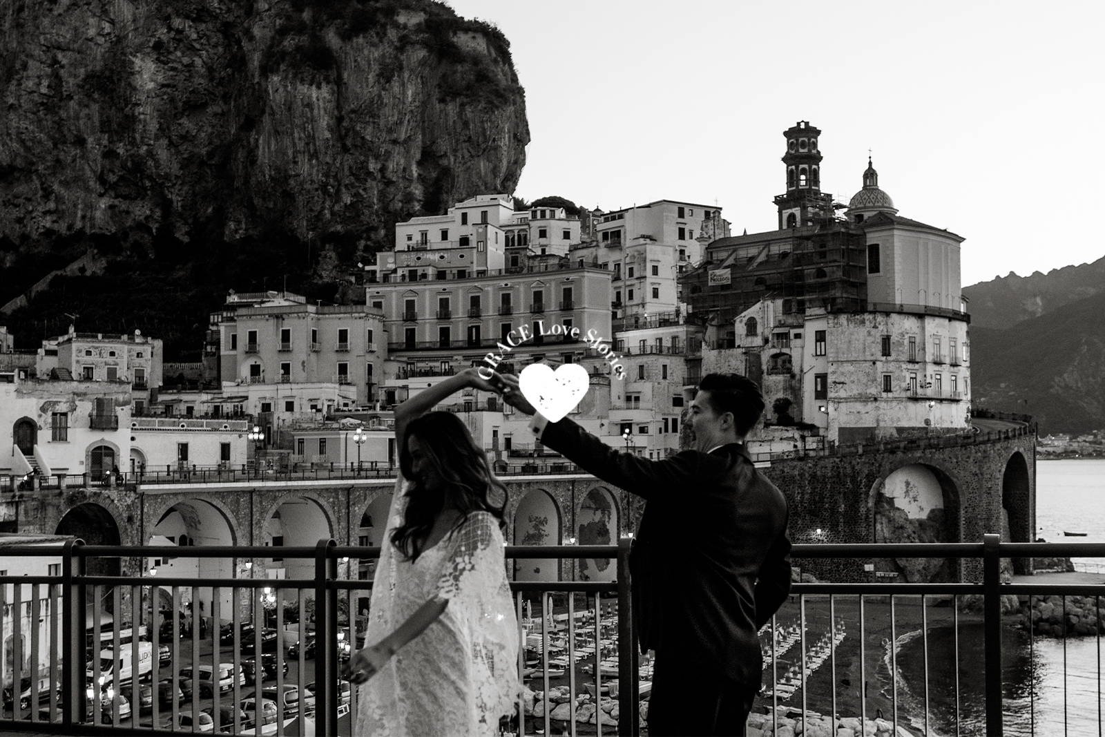 Groom twirling his bride wearing a lace dress on Amalfi Coast 
