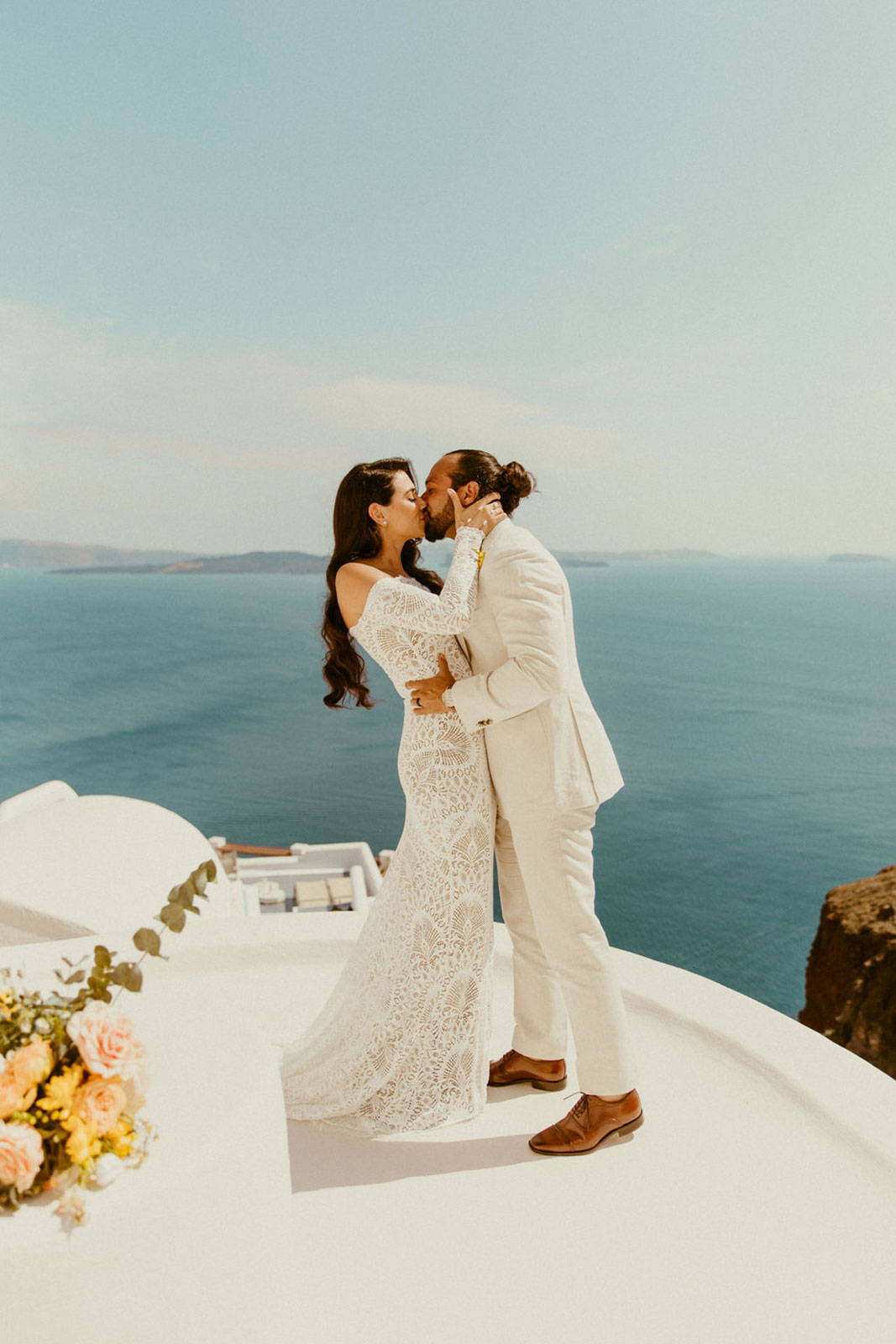 Novios compartiendo un beso con vistas al mar