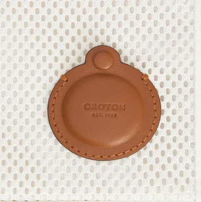 Brown circular leather item with embossed text on a textured background.