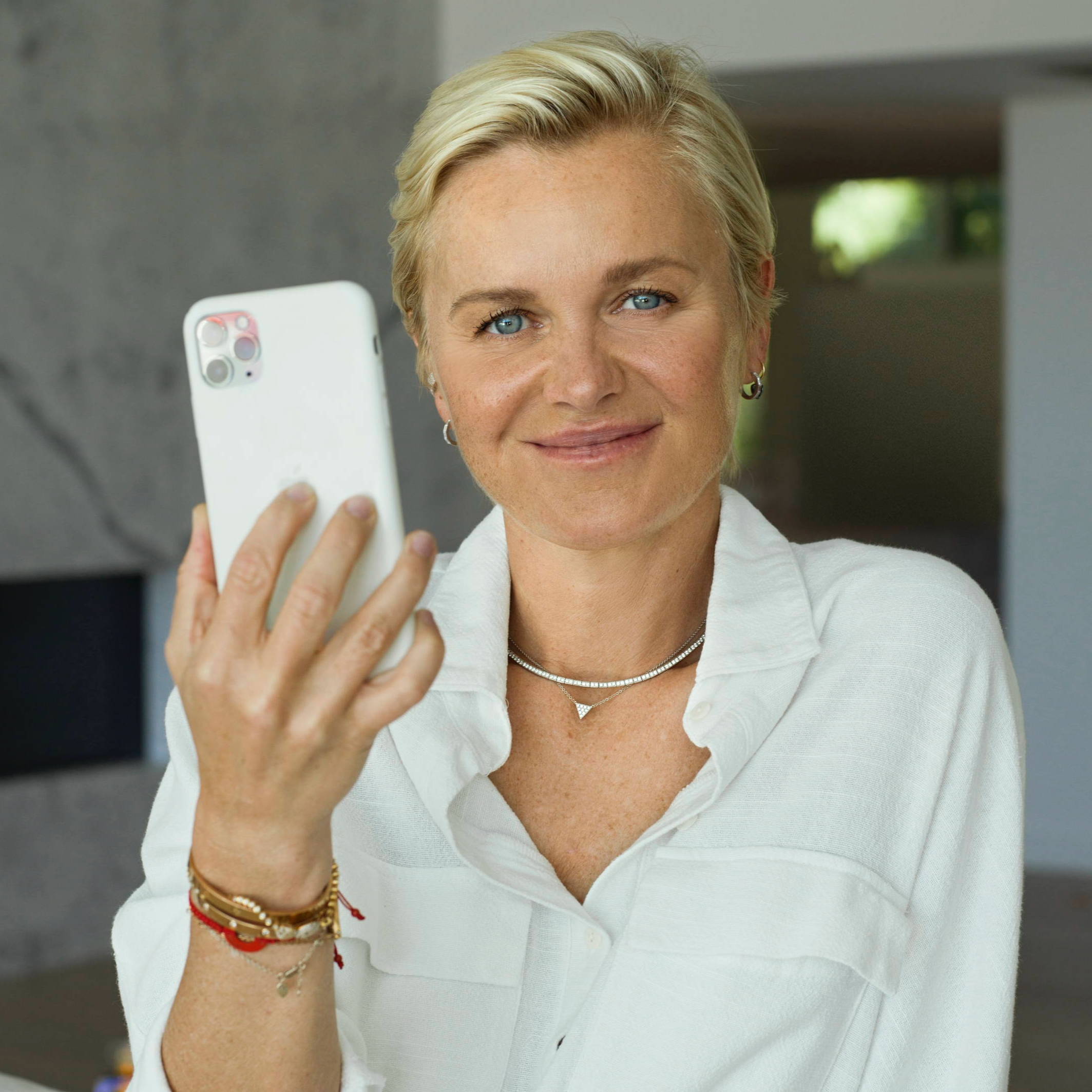 Dr Barbara Sturm holding a white iphone