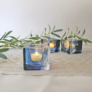 Ingebretsen's banner for unique Scandinavian home decor, featuring glowing brick glass votive candle holders.
