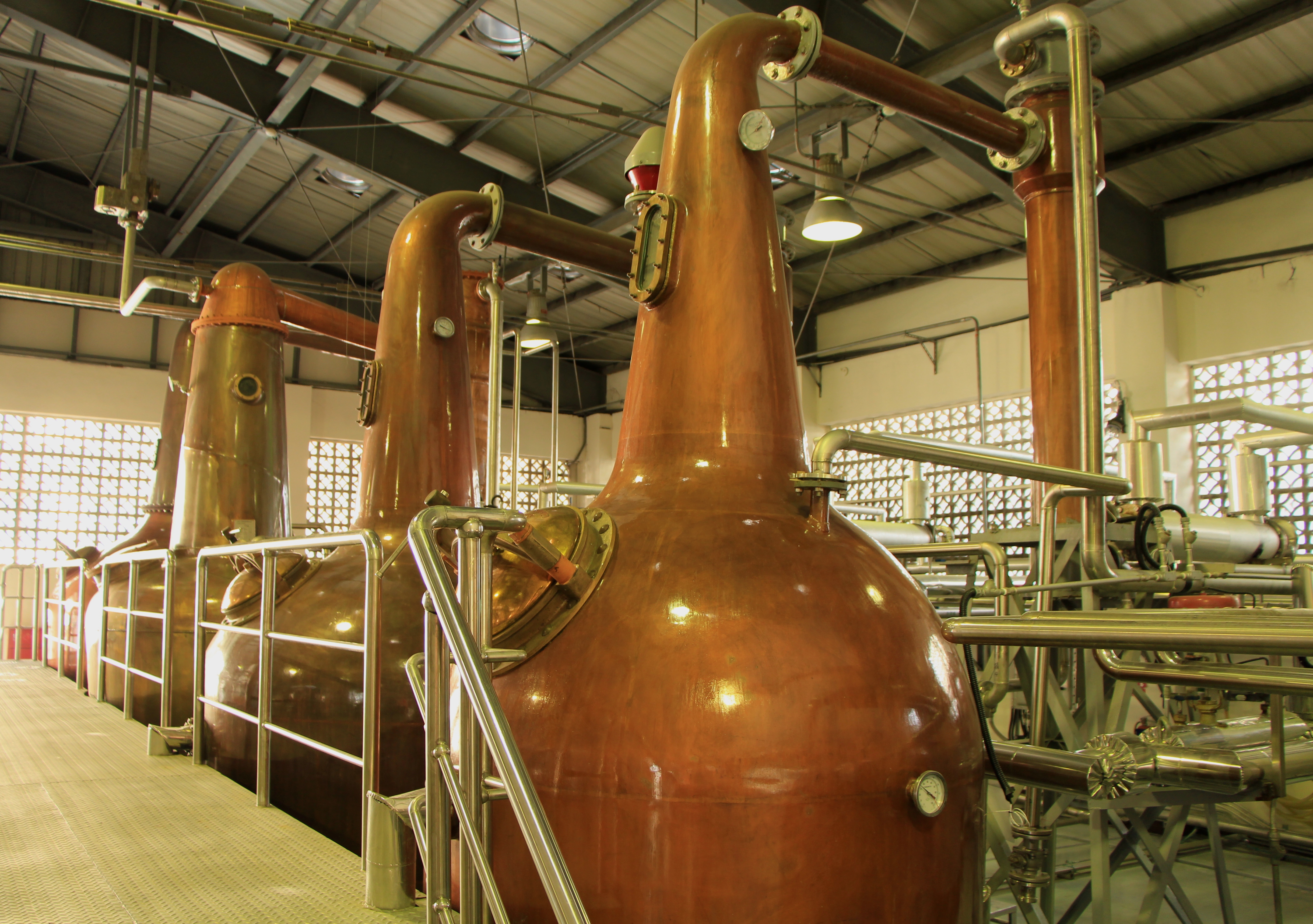 Copper distillation apparatus in a distillery setting.