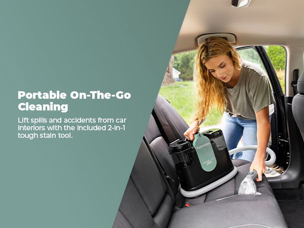 Woman cleaning a car interior with a portable spot cleaner