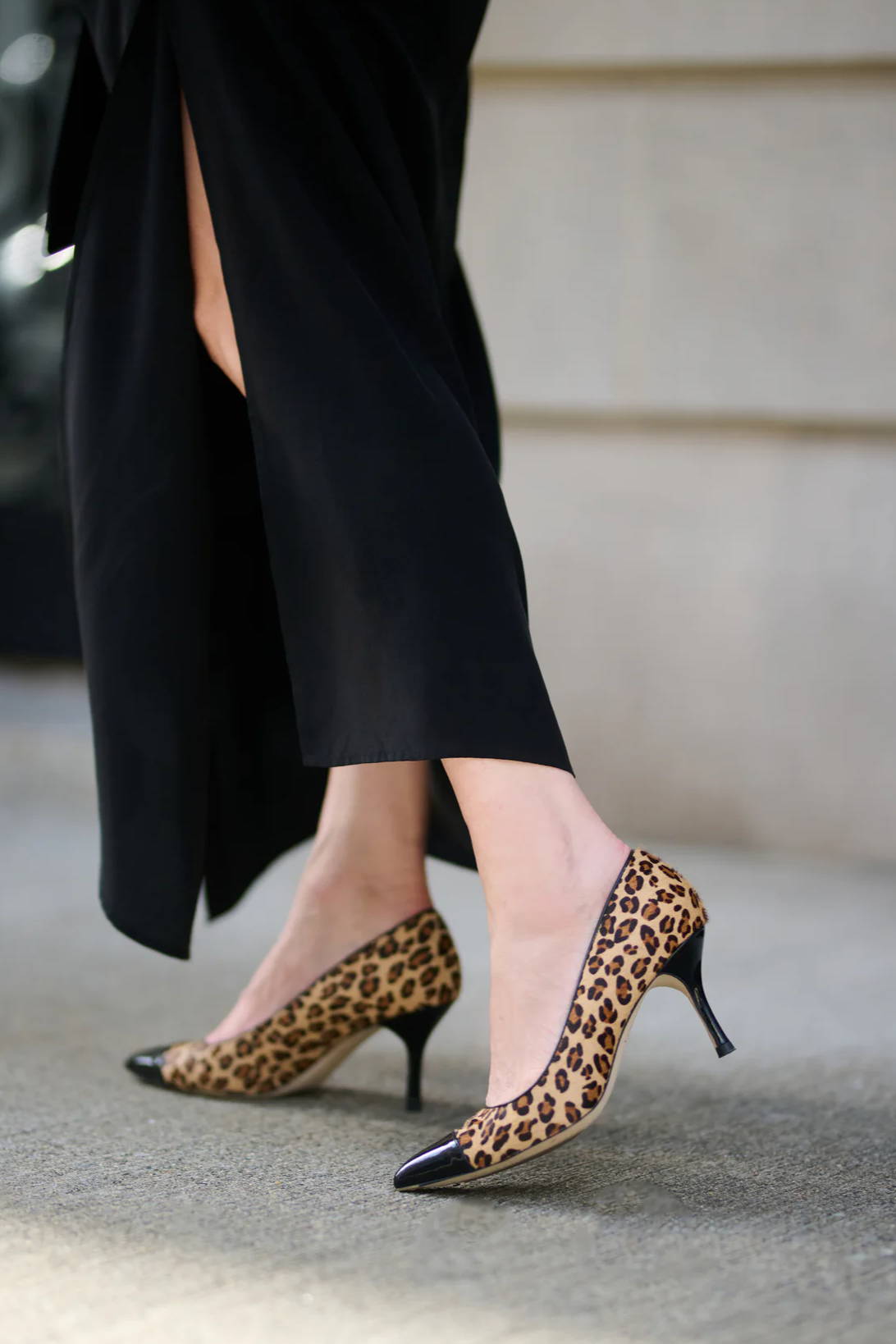 Woman in black dress wearing leopard print high heels.