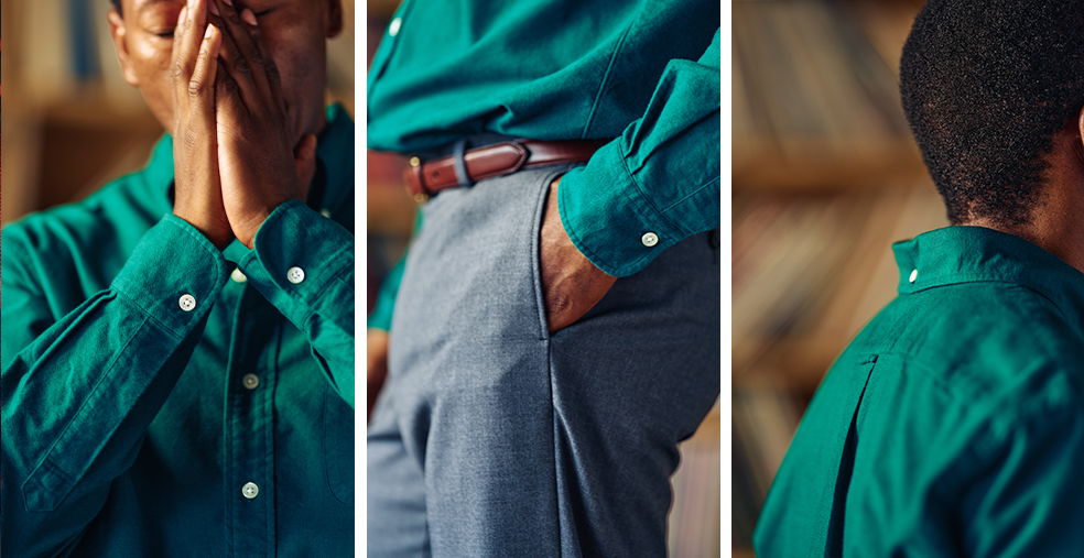 Close-up of a person wearing a teal shirt and grey pants.