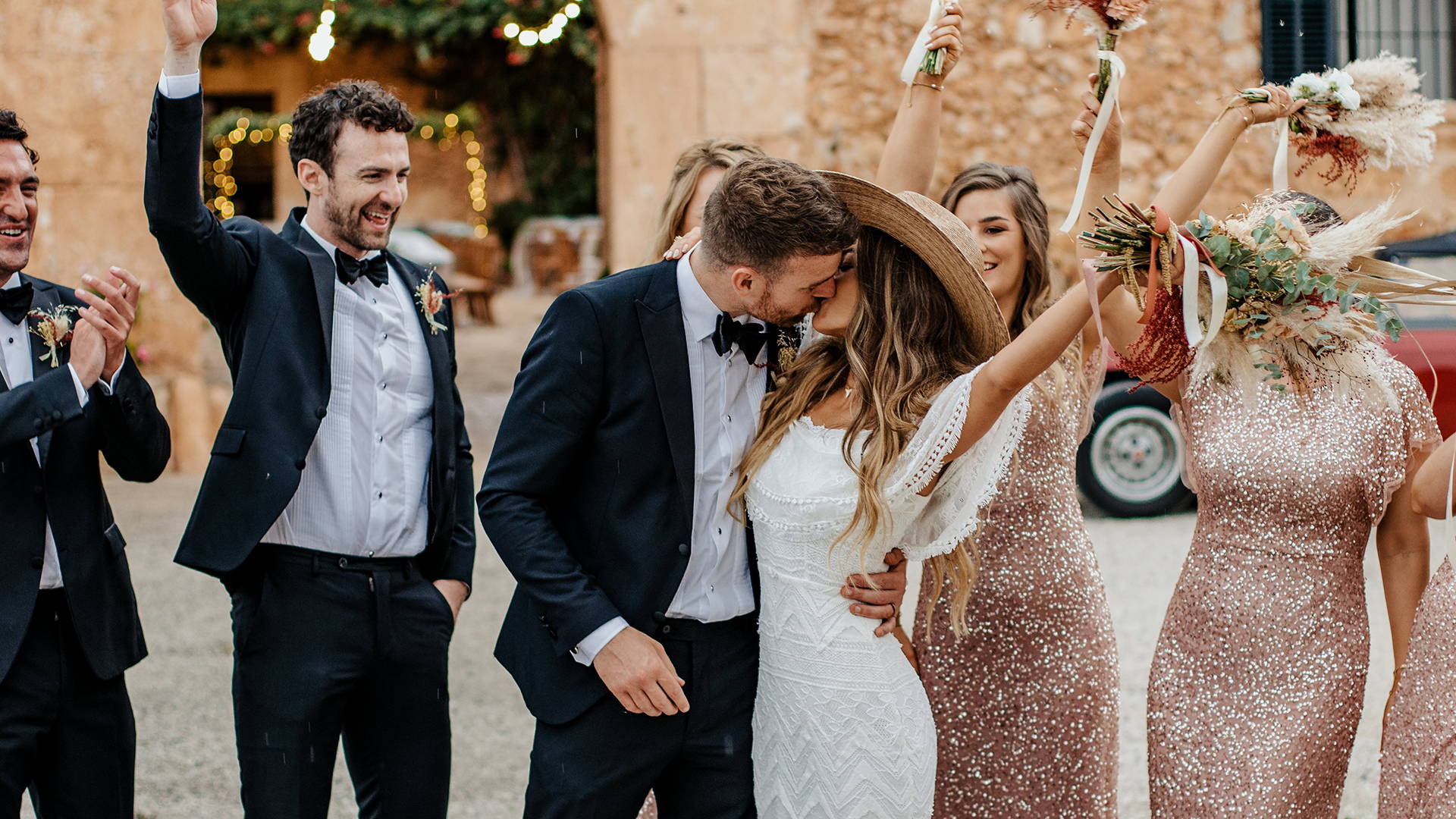 Grace Loves Lace bride wearing the Emanuela wedding dress and straw hat kissing her new husband