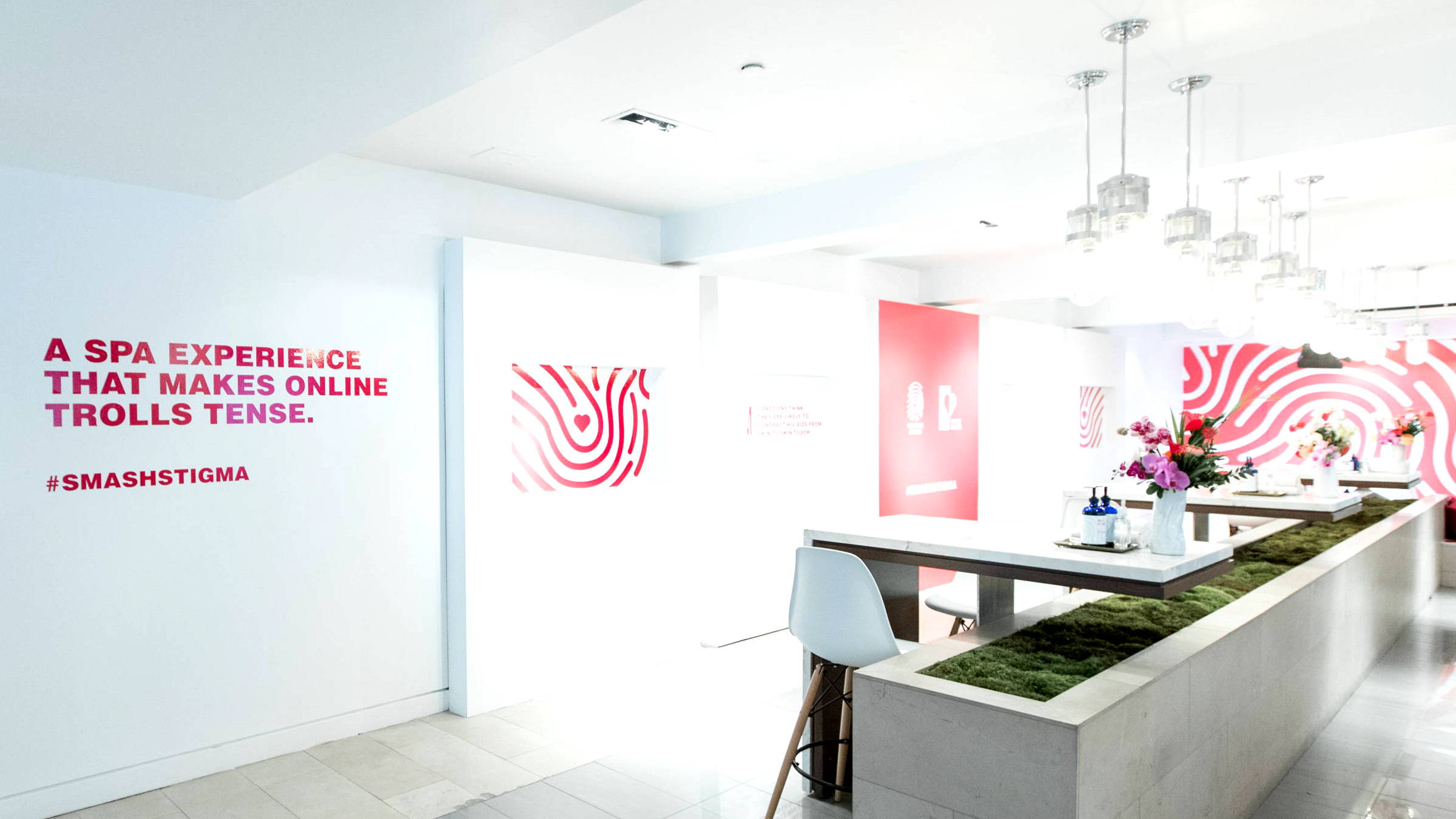 A room with red writing on the wall and floral arrangements on tables
