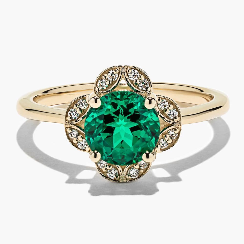 vintage style engagement ring with a lab grown diamond accented halo and a lab grown gemsone emerald center stone by MiaDonna