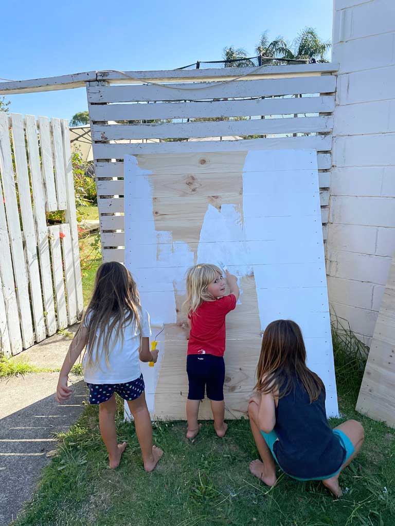 Kids helping to paint their cubby house