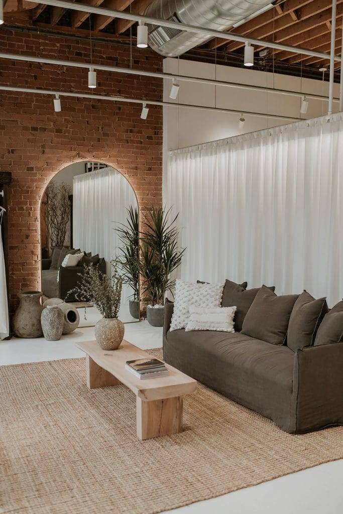 Boutique de mariages aux tons neutres et terreux à Denver, avec un mur de briques rouges.