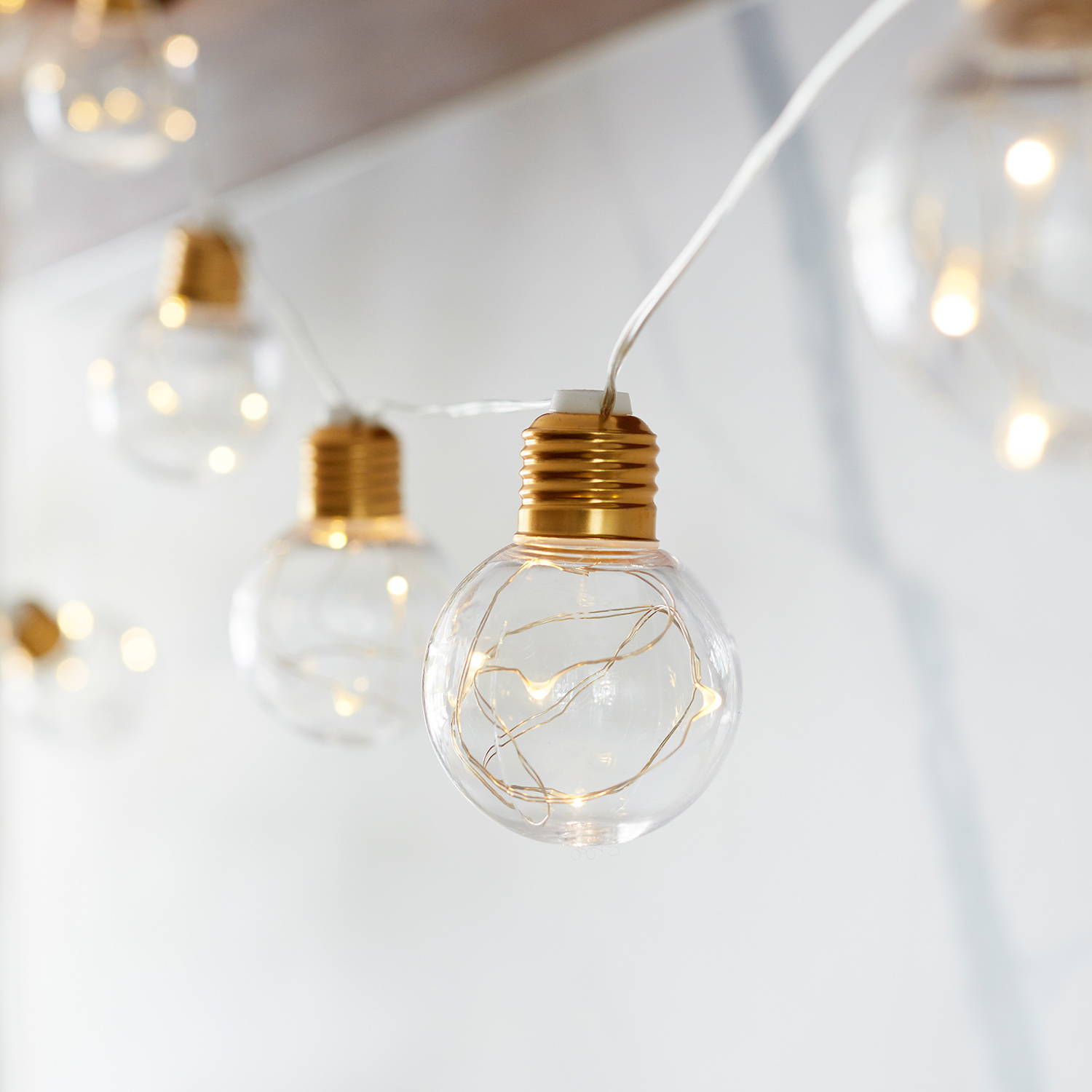 Clear copper bulbs with micro lights inside hanging indoors.