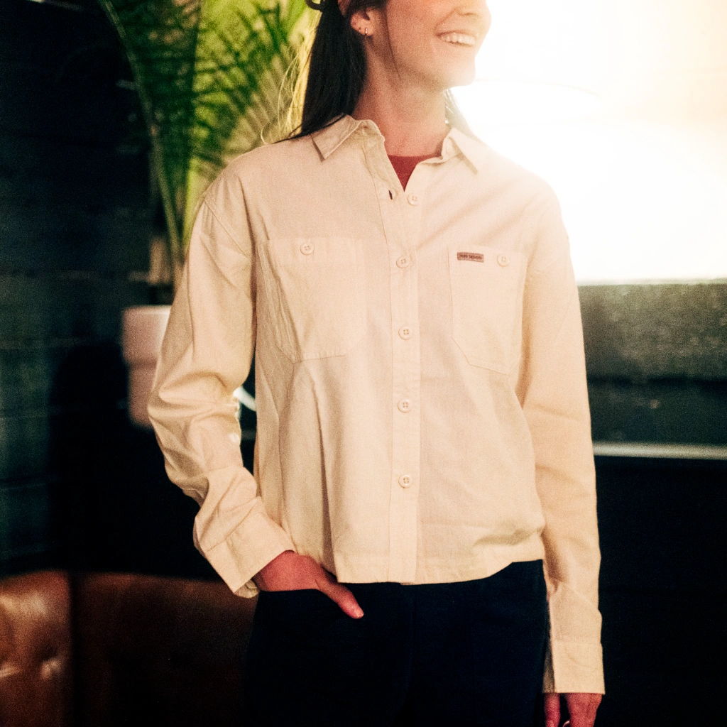 Person wearing a light-colored shirt, smiling in a cozy indoor setting.
