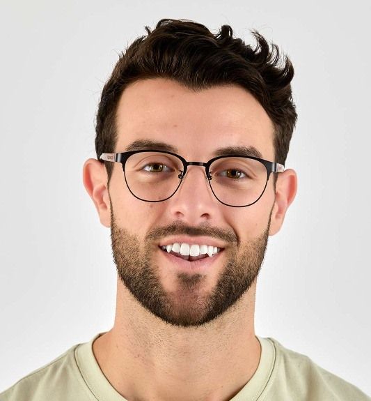 man with oblong face wearing Honest Black, brow-line frames, on a white background